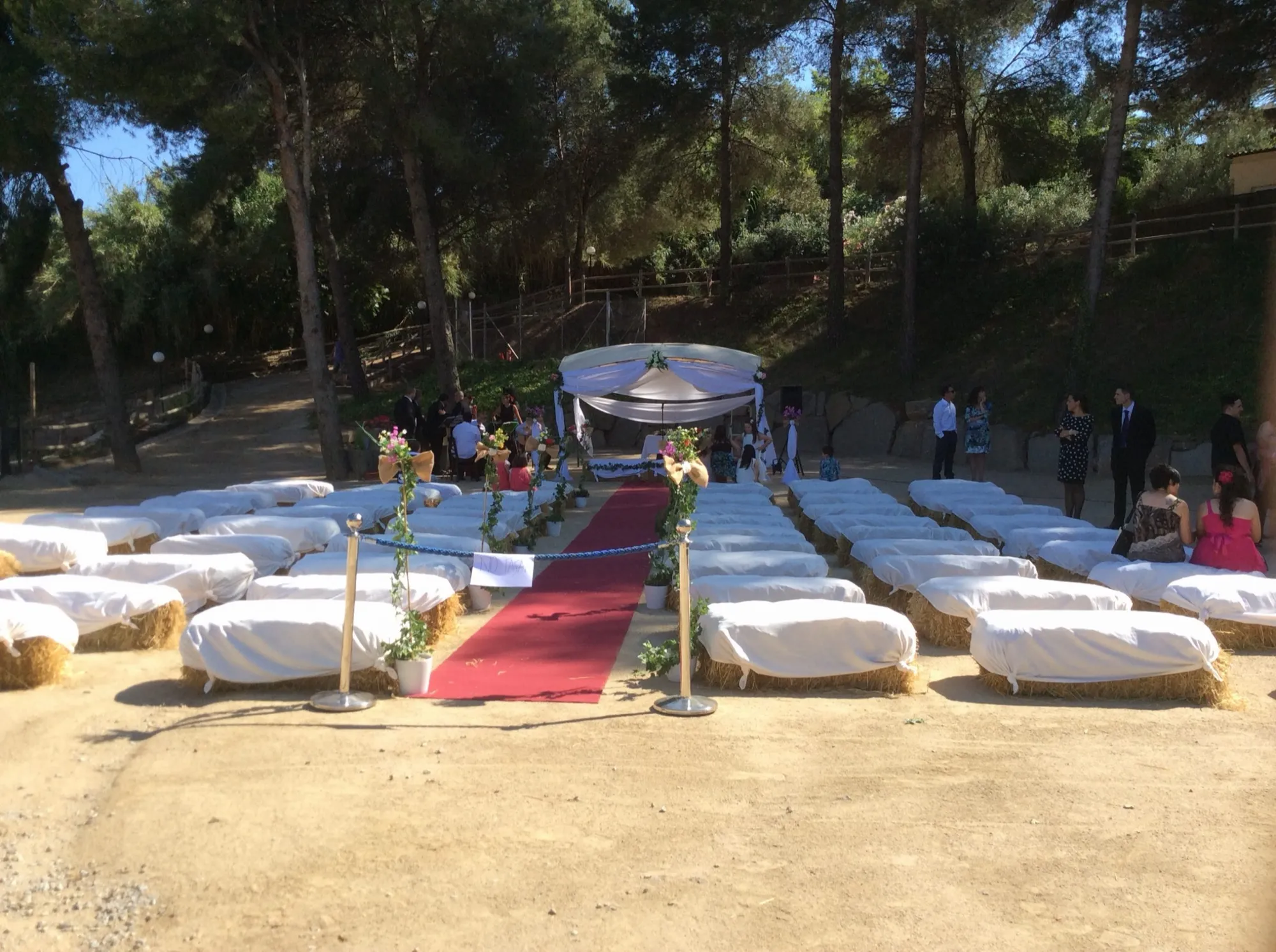 Ceremonia rústica con bancos de paja y alfombra roja