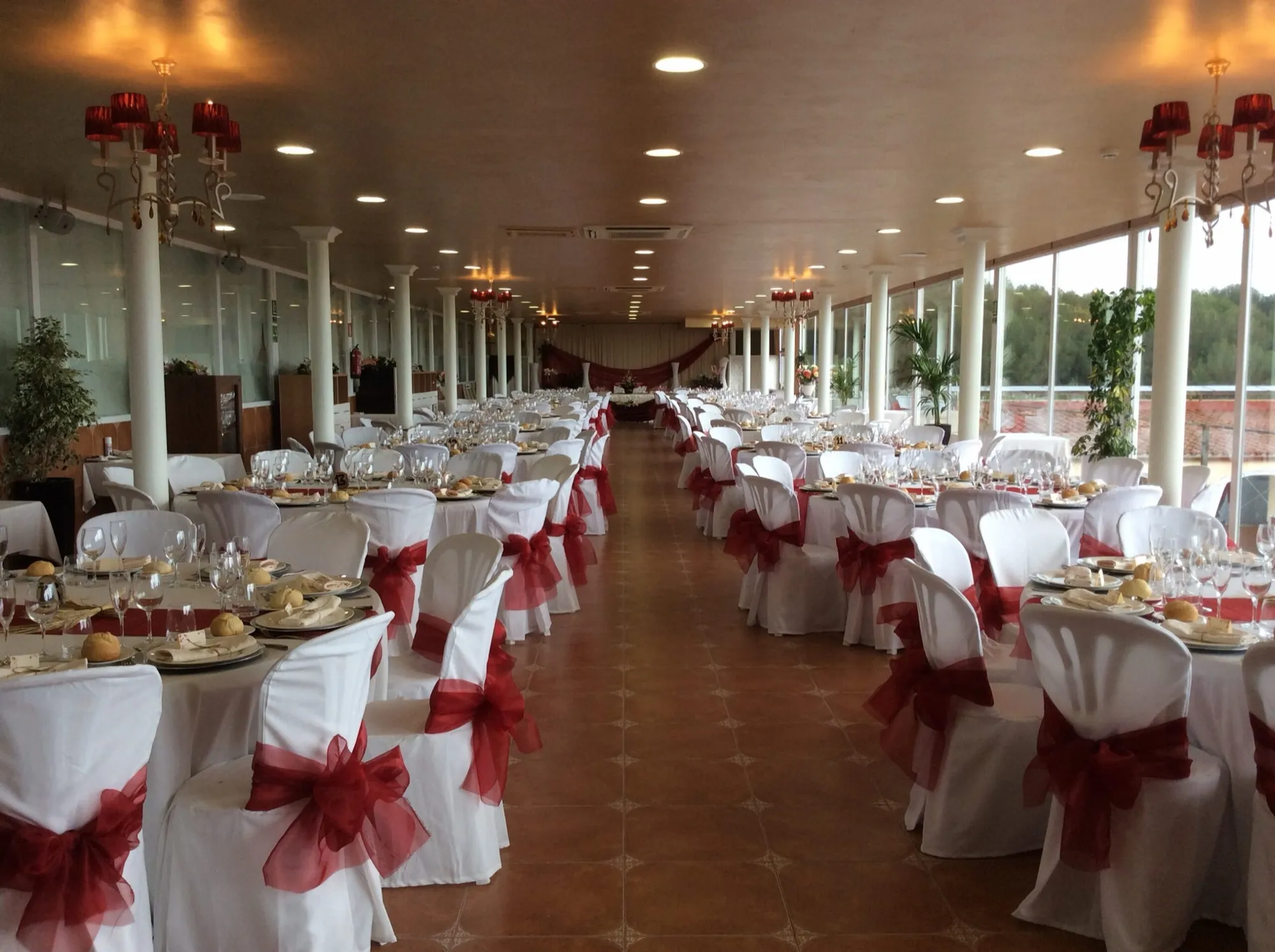Salón interior montado para un banquete con sillas vestidas de blanco