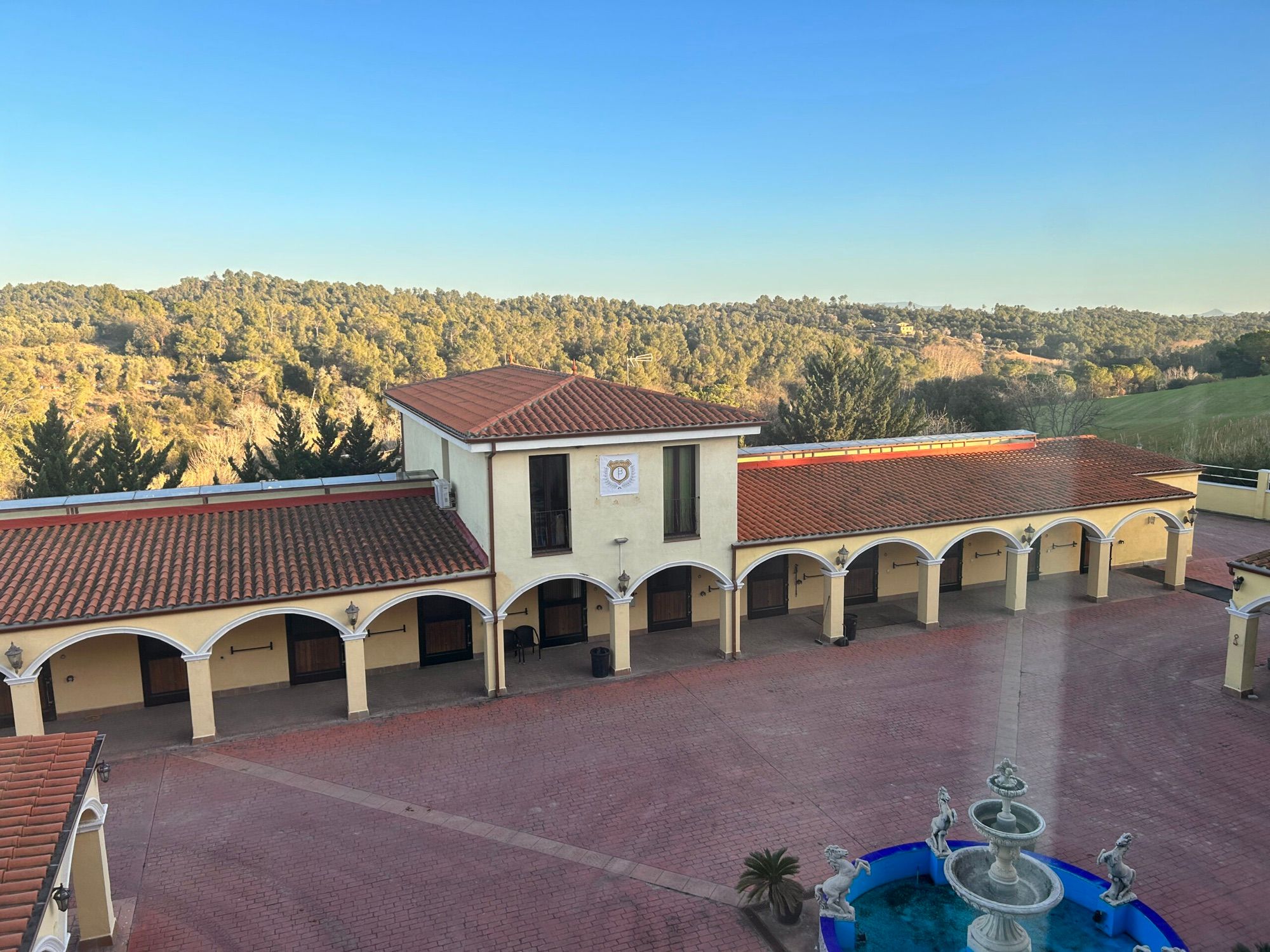 Vista aérea de la finca con el patio de arcos y los bosques del Vallès